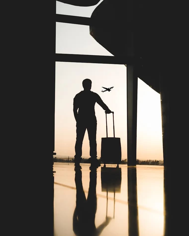 Man standing in front of a window with a plane flying outside